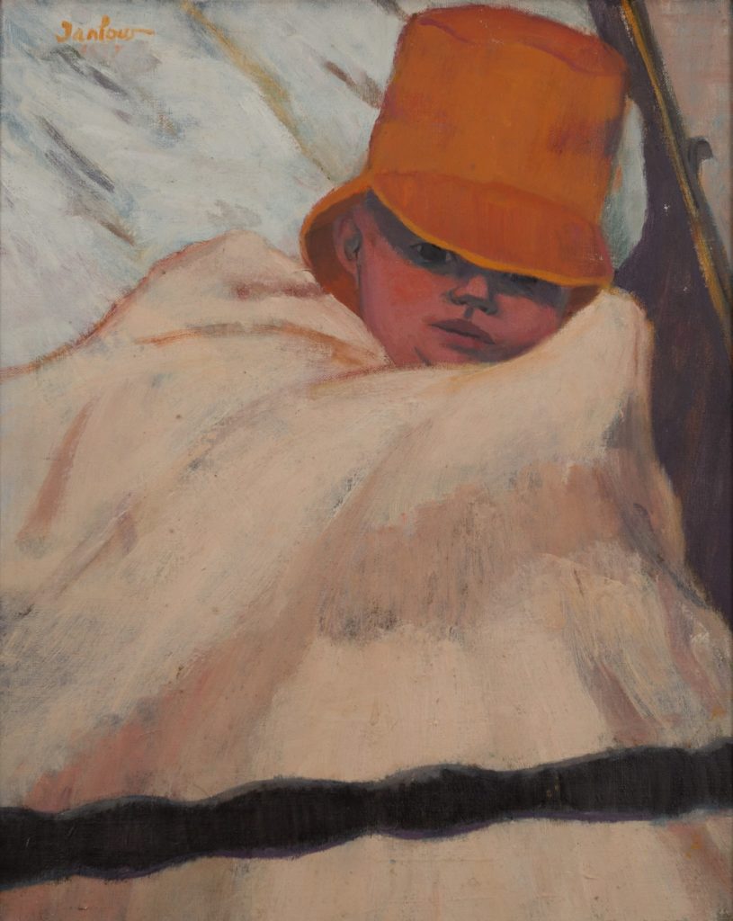 Baby in red had wrapped in a peach blanket in front of a white-blue background