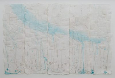 Five strips of white paper, hanging, with drips of light blue, grey, and white paint. Geometric shapes are pasted across the middle of the papers.