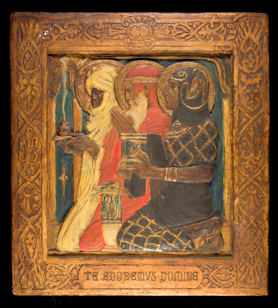 Painted plaque with a wide decorative boarder with three men kneeling holding various objects and gold halos behind their heads.