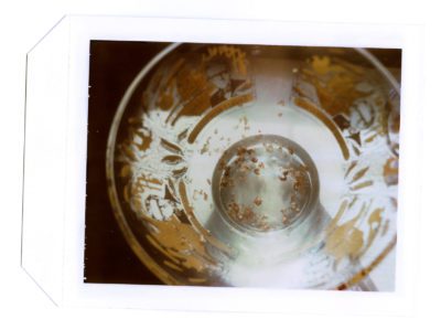 Photograph of a glass bowl with gold details and remnants of some grain at the bottom.