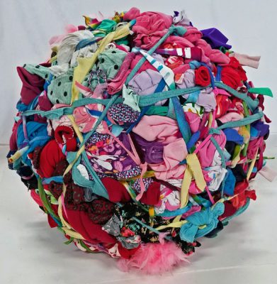 Large ball made up of various clothing items, tied together with strips of cloth.
