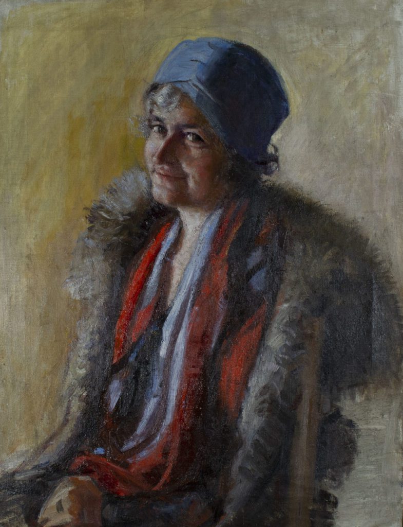 Portrait painting of an older woman from the waist up, seated, wearing a fir coat, several layers of clothing in red, blue, and white. She is light skinned, looking out at the audience, and her grey hair is up under a blue cap.