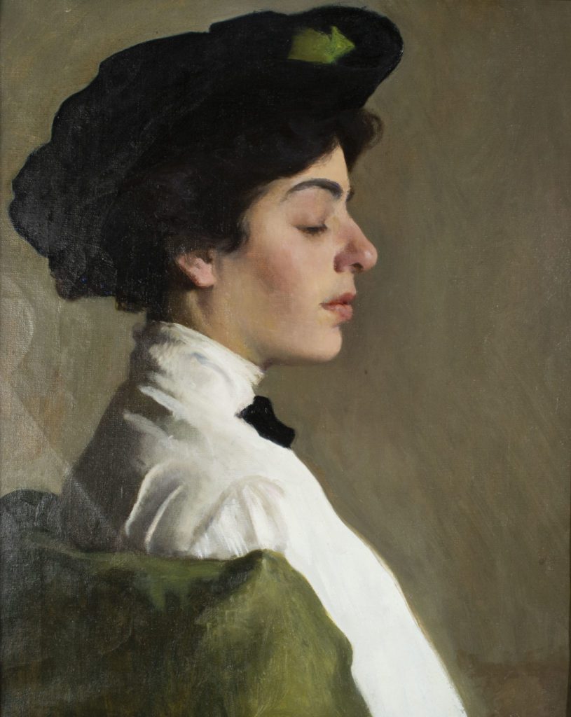 Portrait painting of a woman in a high necked white shirt, black bow at her neck, and a black hat seated in a green chair. Her brown hair is pinned up under her head with cream skin and calm expression while looking downward.