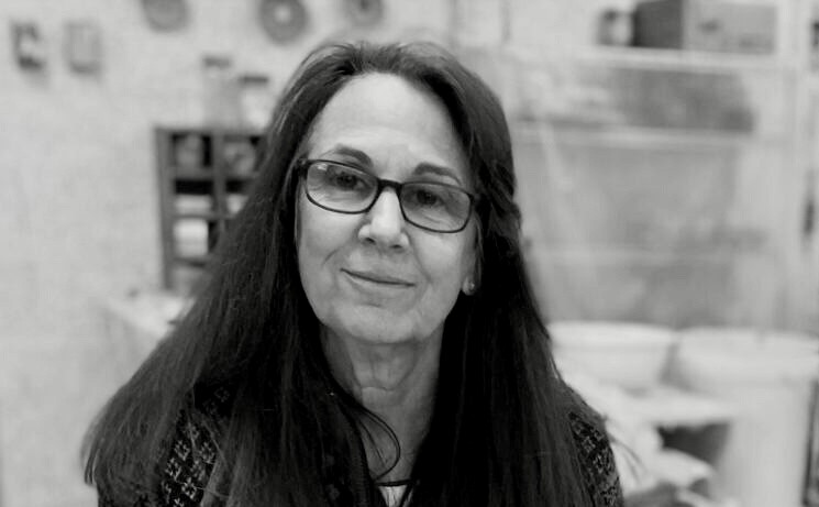 Black and white photograph of an older woman with long straight dark hair, wearing glasses.