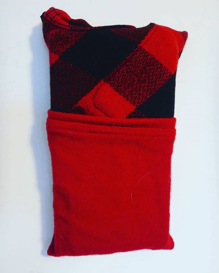 Photograph of a red fabric square with solid red on the bottom and black and red checkered on top.