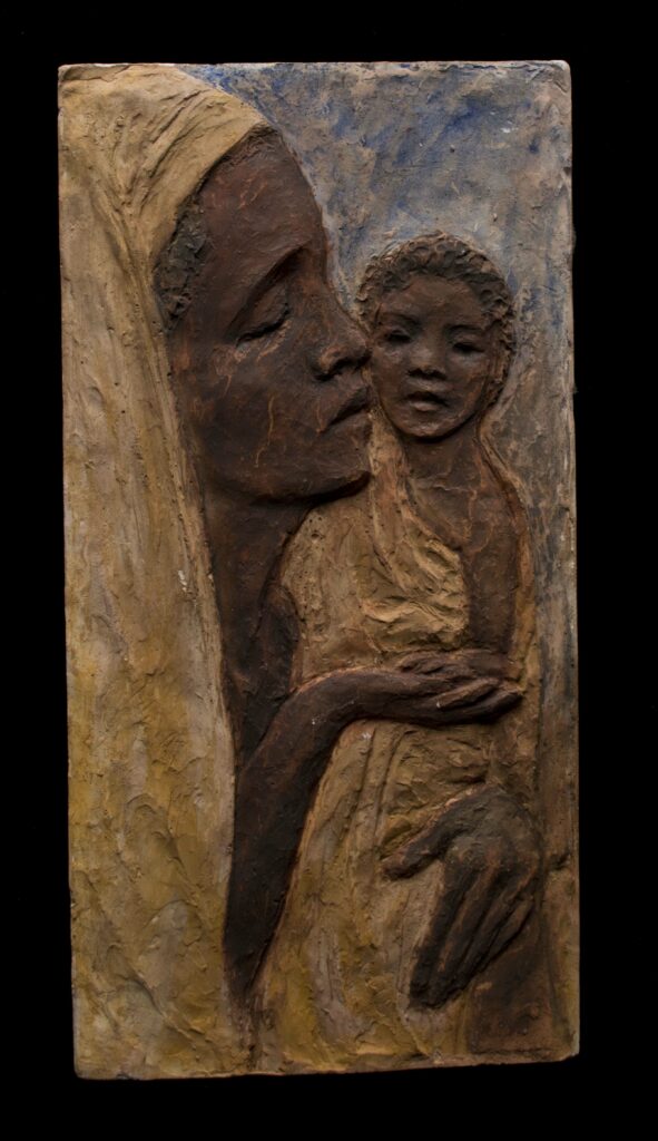 Painted rectangular plaque of an African mother in a tan head scarf holding up and kissing a small baby.