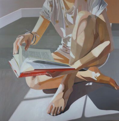 Painting of an interior room grey floor with peach-grey walls just visible in the upper left corner. In the center in light from a window is a woman seated cross legged in a white t-shirt with gold stars. She is holding reading a book.