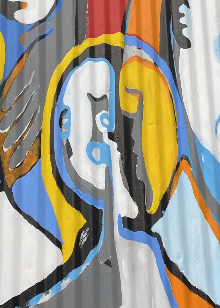 Close up of a mural on a metal corrugated surface. The image is of oval abstract faces, looking towards each other. The faces are outlined in black with additional colors of yellow and blue.