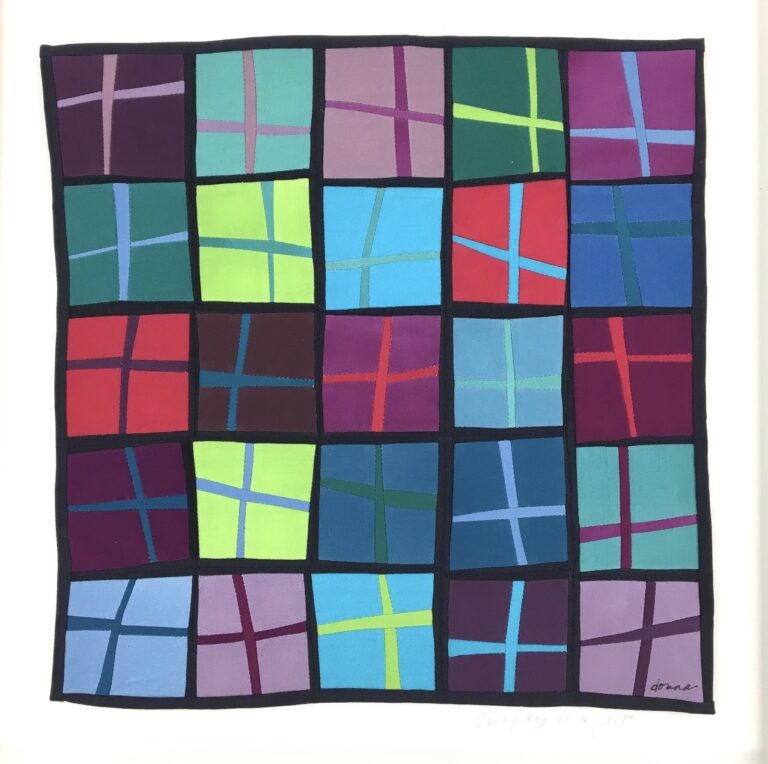 Photograph of a framed textile with skewed squares of various blues, greens, and purples with black boarders between each. Each square has an off set cross shape in a contrasting color.