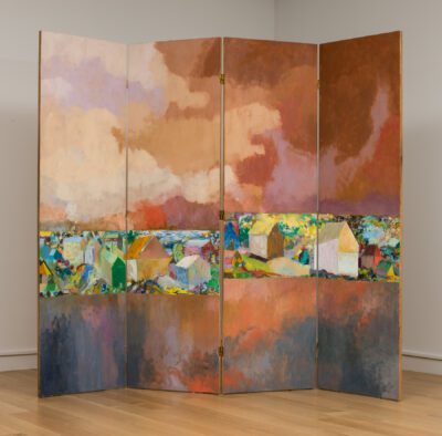 Photograph of a folding screen with molted red-pinks on top and pink-purples on the bottom, Just below center are strips of landscapes with simple house shapes throughout.