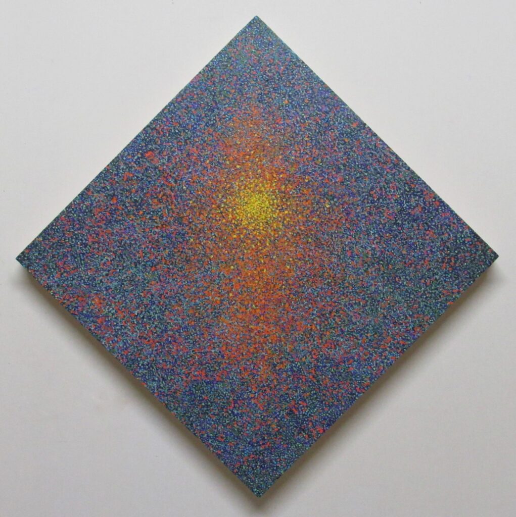 Diamond painting with a speckled background of blues, greens, reds, and blacks. In the center is a concentration of orange speckles with a yellow center.