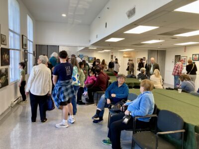 people mingling in a studio enjoying food and art